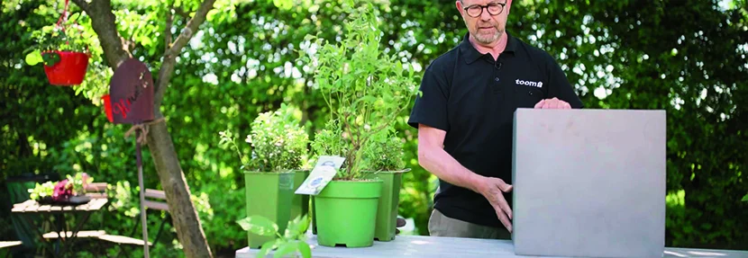 Person baut einen Pflanzkasten zusammen.